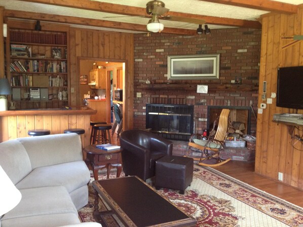 knotty pine living room with dry bar, fireplace and flat screen tv