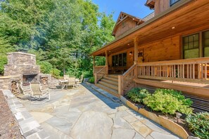 Large stone patio with outdoor fireplace, dining, covered front porch at Valle Crucis Overlook