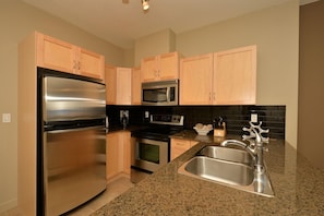 Kitchen has granite countertops and all the cooking equipment you need