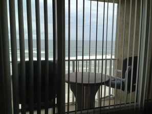 View of balcony with high table and chairs for a better view of the beach.