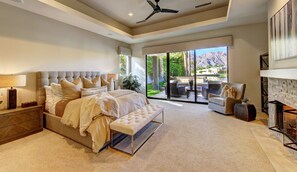 Elegant primary suite with fire place, reading nook and luxurious bedding.
