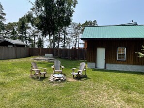 Large fenced yard with firepit, chairs and picnic table