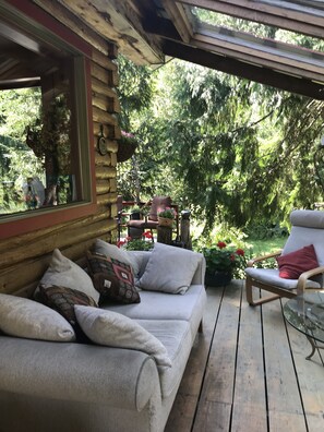 Covered deck with couch, chairs and blankets for those cooler evenings. 