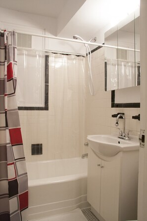 Bathroom with bath tub and telescopic shower head