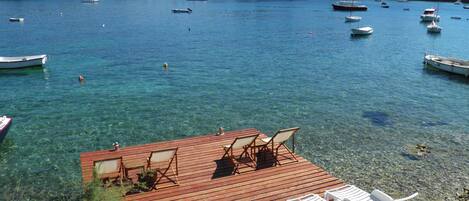 Private wooden pier with the beach in front of the house