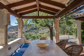 Outdoor eating area with nearby Fornalutx in the background.