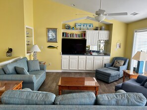Beautiful top floor living room with a 50" flat screen TV, & ocean view