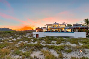 THE HOUSE IS SET BACK ON THE BEACH AMIDST GRASSY DUNES