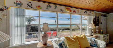 Sunshine floods the room as you look out over the white sands and blue water.