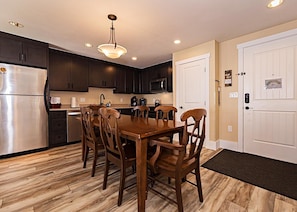 Open concept kitchen, dining and living area with gas fireplace, flat screen TV, pull-out sofa and views of the slope