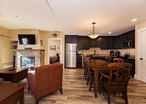 Open concept kitchen, dining and living area with gas fireplace, flat screen TV, pull-out sofa and views of the slope