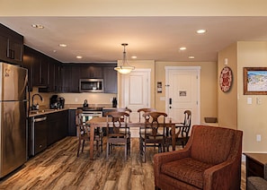 Open concept kitchen, dining and living area with gas fireplace, flat screen TV, pull-out sofa and views of the slope