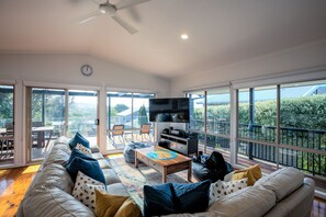 Living area with 8-seat couch and 65-inch TV