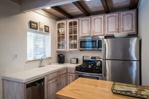 Efficiet kitchen is fully stocked with cooking utensils, coffee, tea and spices.