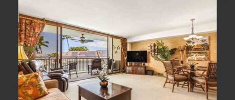 Open living room to beautiful lanai with peek-a-boo ocean views