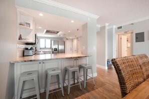 Bar top seating with bar stools overlooking the kitchen.