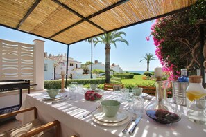 Terrace with teak wooden dining table, BBQ and stairs to your private garden