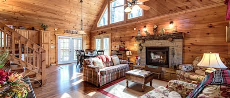 You’re going to love it here - A vaulted ceiling, lustrous wood-planked floors and walls, a stone-surround fireplace, plenty of well-cushioned seating: Lazy Cub Lodge’s great room is a delight.