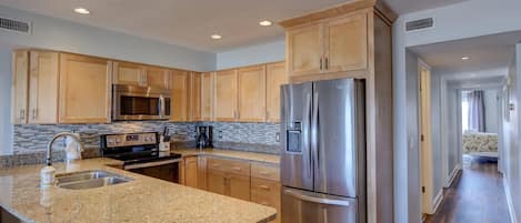 Modern kitchen with all stainless steel appliances and granite countertops 