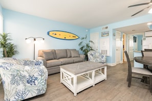 Open concept living area with queen size sleeper sofa and flat screen TV