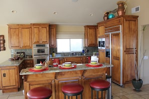 Another view of Kitchen and counter with swiveling bar stools
