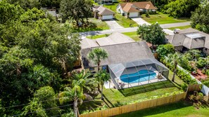 Aerial view of the private backyard with a screen enclosed heated pool.