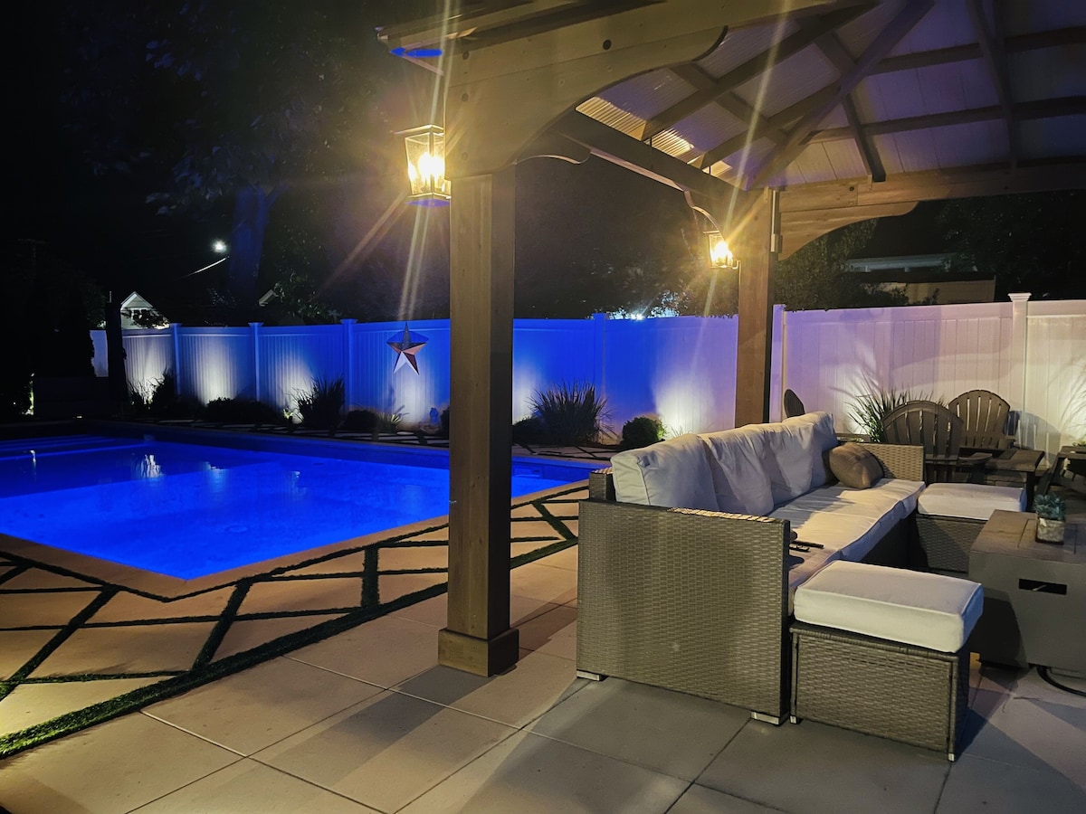 Poolside play with a relaxing hot tub, fire pit, & gazebo with a television.