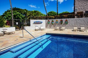 Beautiful swimming pool and hot tub area with sun loungers.
