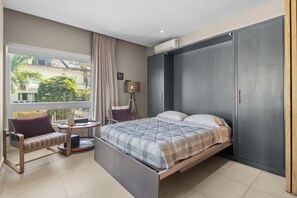 Living Room - features a double-size Murphy bed that folds away effortlessly to maximize space, sliding doors for added privacy when used as a second bedroom, and a cozy private balcony with charming street views.