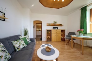 Ferienwohnung Chiemsee für 1-2 Personen (50 qm, OG)-Wohnzimmer mit Blick in Eingangsbereich und Küche