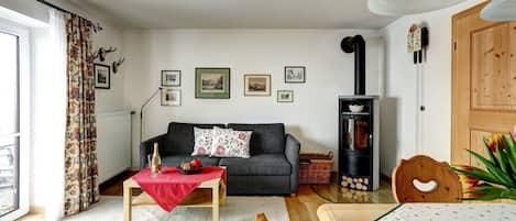Ferienwohnung Untersberg für 1-2 Pers., 69 m², Schlafzimmer, Wohnzimmer, Küche, Terrasse-Wohnzimmer mit gemütlicher Couch und Schwedenofen
