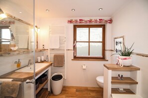 3-Raum-Wohnung Kaiserwinkl exclusiv, 108qm, 2x Dusche/WC, 2 Extra-Schlafräume, Küche, Terrasse-Luxuriös modern und doch einladend gemütlich: das Bad der Kaiserwinkl Exklusiv mit Badewanne und ebenerdiger Regendusche.