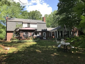 The back yard with: screen house, patio w/ BBQ and glassed-in porch.