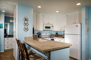 The kitchen is equipped with dishes, pots and pans, and cooking utensils.