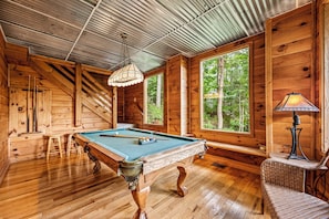 The basement game room is home to a pool table, as well as a washer/dryer.
