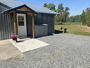 Main entrance. Garbage, recycle, compost bins inside grey unit. 