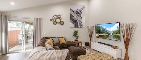 Open concept living room with 20' ceilings and 75" 4K HDTV and cabe TV. 