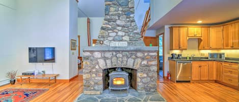 A floor-to-ceiling fieldstone fireplace highlights the living space.