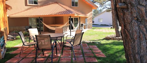 Outdoor patio area with table and BBQ.