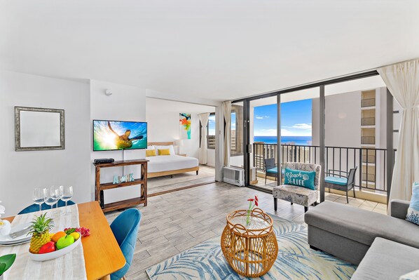 Cozy living room with great ocean view from the lanai, a window AC, cable TV, and a sliding door that separates the bedroom to the living room