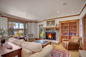 The living room features a wood fireplace and water views