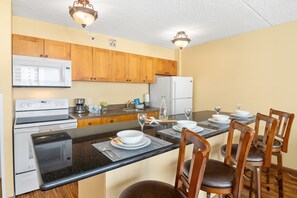 Fully equipped kitchen with full-size appliances, dining counter with 4 bar stools.