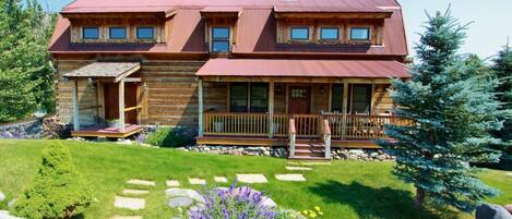 Flowers and green grass surround the home in late spring through the summer.