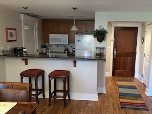 View of condo entry from dining area-kitchen on left, 2nd full bath on right.