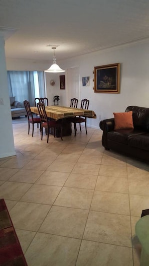 Looking into the dining area from the living room. Sunroom in the back.