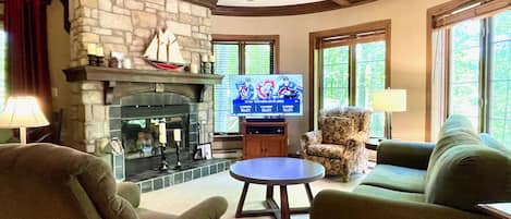 Spacious turret-style living room with stone fireplace