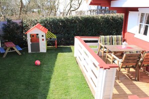 Terrasse mit Kinderspielhaus und Kindersitzecke im  Garten