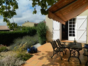 Private front patio surrounded by hedge has doors into dining room and entryway.