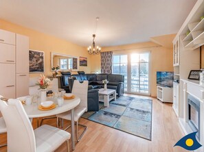 Wohnzimmer mit offener Küche und Zugang zum Balkon