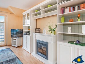 Wohnzimmer mit offener Küche und Zugang zum Balkon